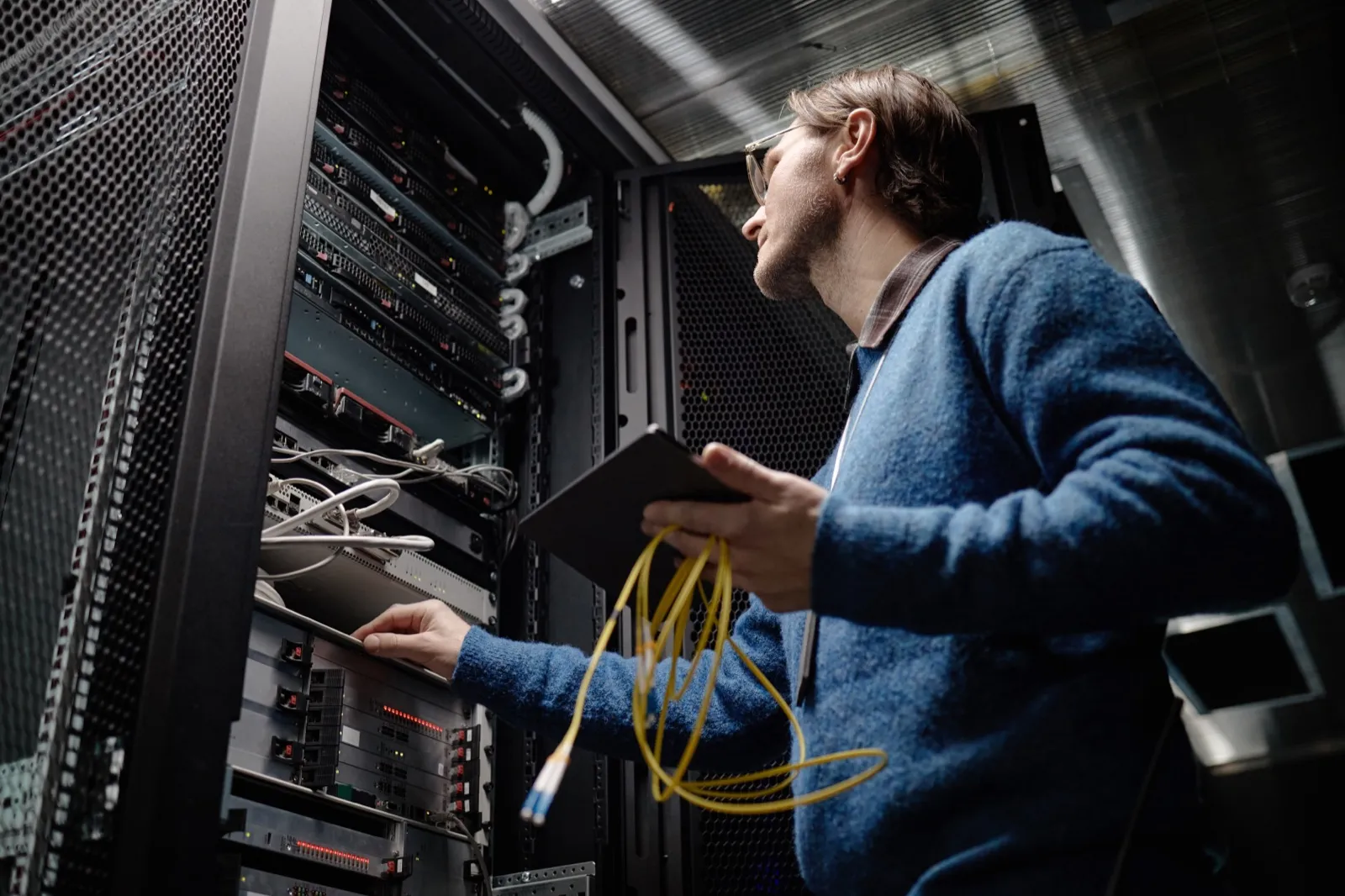 Engineer checking a server rack with a tablet during managed IT monitoring