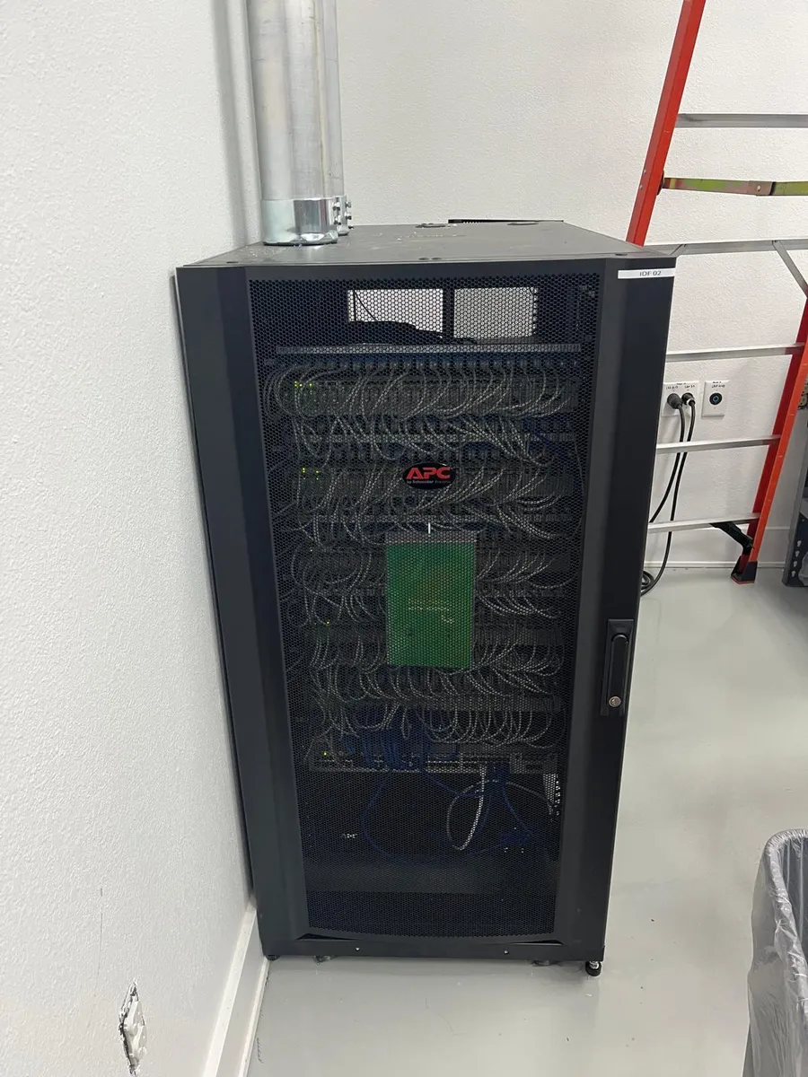 Black network cabinet with UPS in a finished equipment room